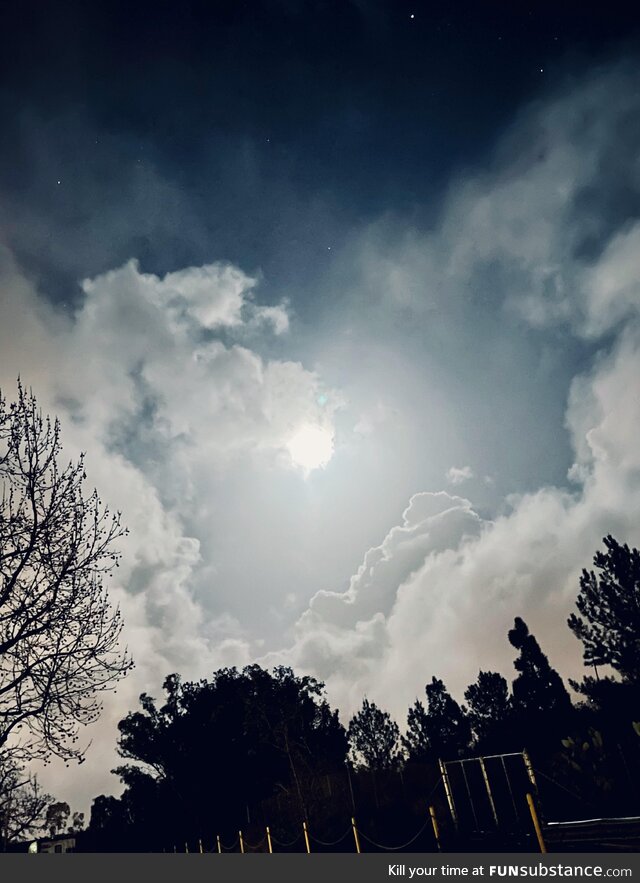 Bright moon over cloudy night sky