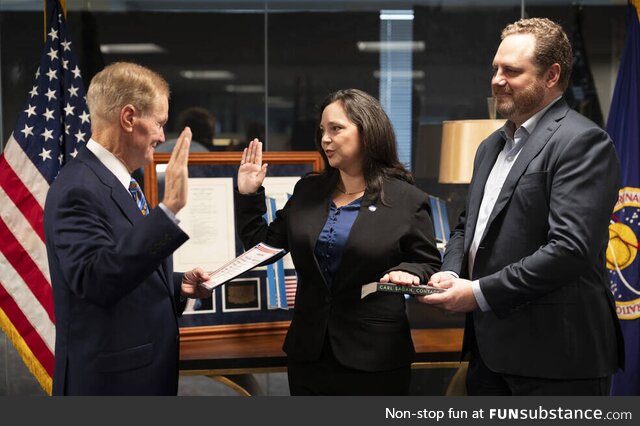 Charity Weeden is sworn in at NASA. Look closely at the book she's swearing in on