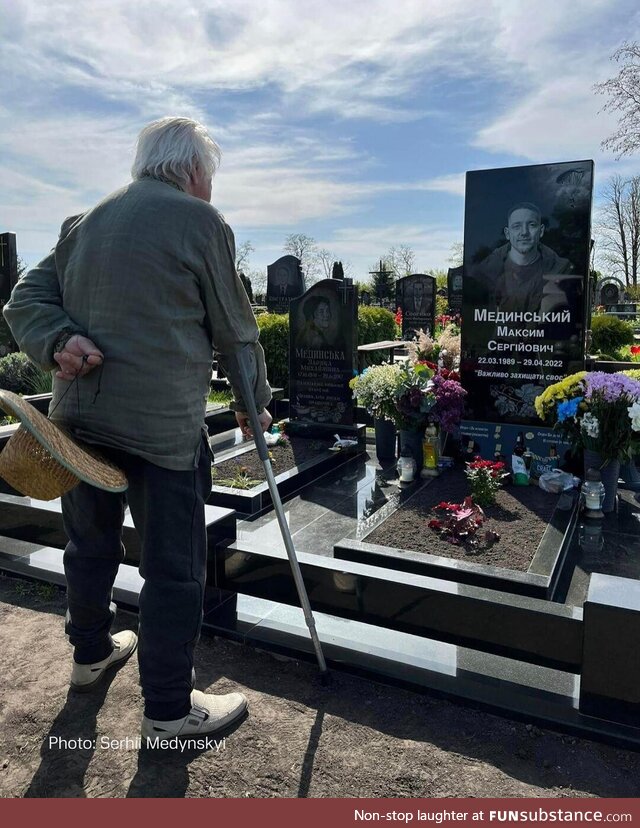 Grandfather standing next to the grave of his grandson, who was killed by Russians two