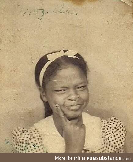 A young girl poses in a photo booth during the 1930s