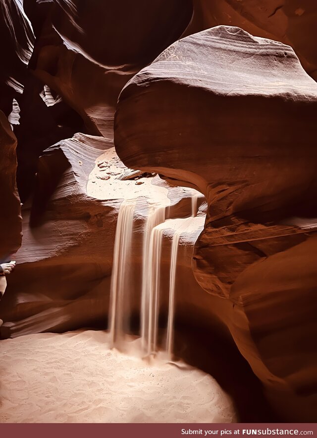 Caught this photo of a sand waterfall (sandfall?) induced by the guide at Antelope