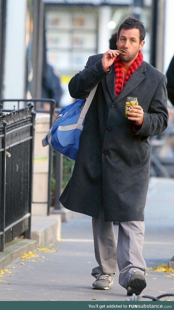 Adam Sandler walking around New York City eating a jar of pickles