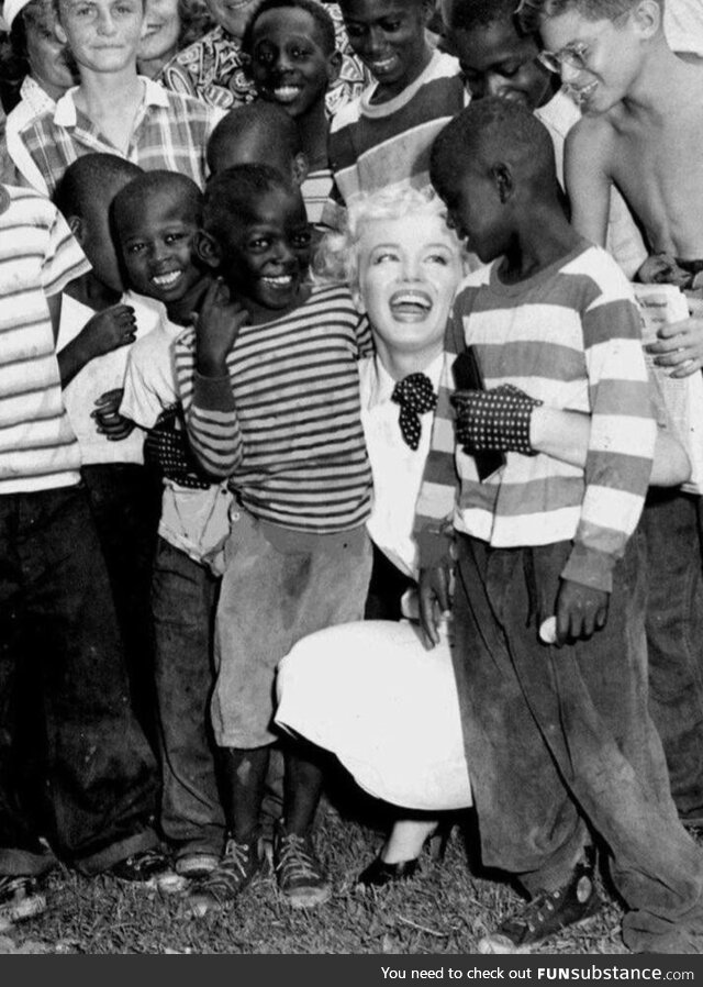 Marilyn Monroe embracing some children at a parade