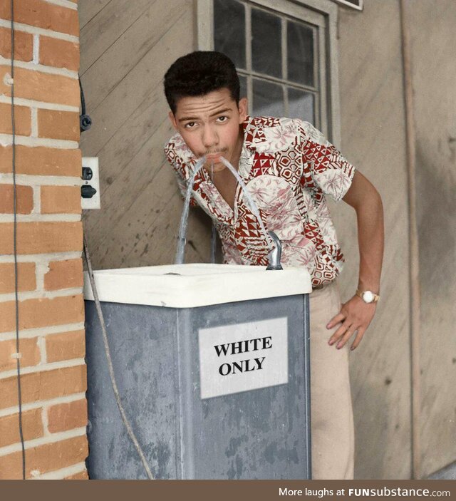 Cecil J. Williams drinking from the "White Only" fountain in 1956. -colored-