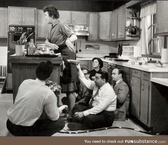 Multiple staffers hunkered around Julia Child during a taping of The French Chef