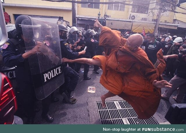 Thailand monk kicking police during a protest. November 2022