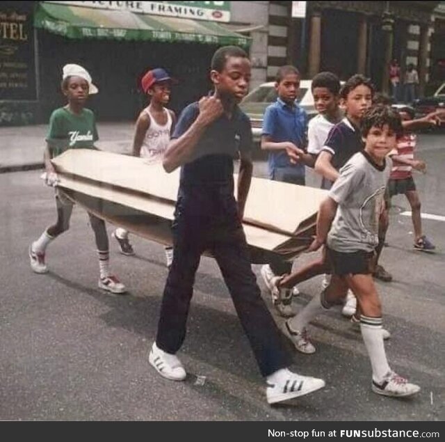 Kids carrying cardboard for breakdancing in New York City (1983)