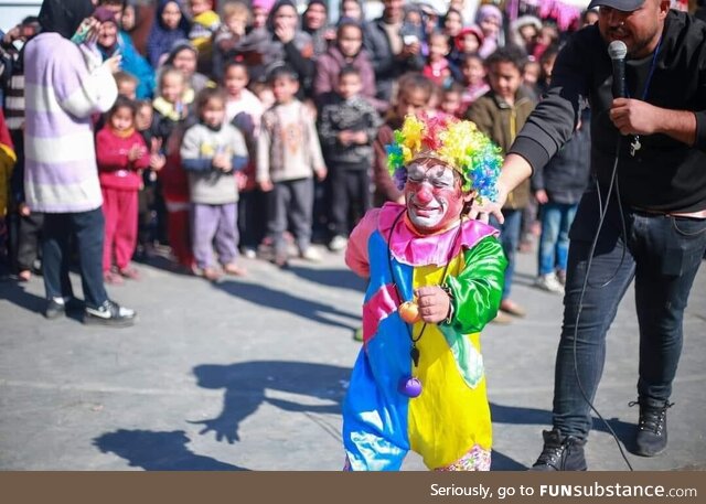 A clown in Gaza cannot hold his tears as he turns his back to the traumatized kids in a