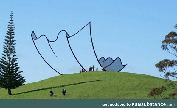 This Sculpture in New Zealand looks like a Cartoon piece of paper on top of the Hill