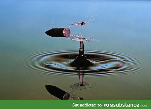 A bullet splitting a water droplet in half