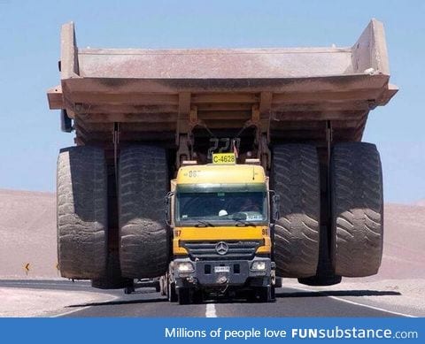 This truck transporting a massive mining truck looks like a tiny toy