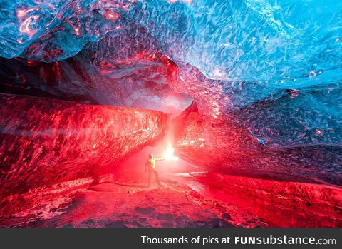 An Icelandic ice cave, lit up by a burning flare
