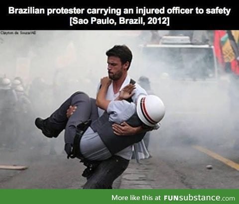 Brazilian protester carrying injured police to safety