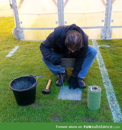 This gentleman is sewing individual strands of artificial grass into bare spots