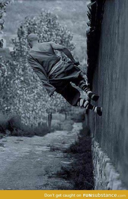 A shaolin monk running on a wall