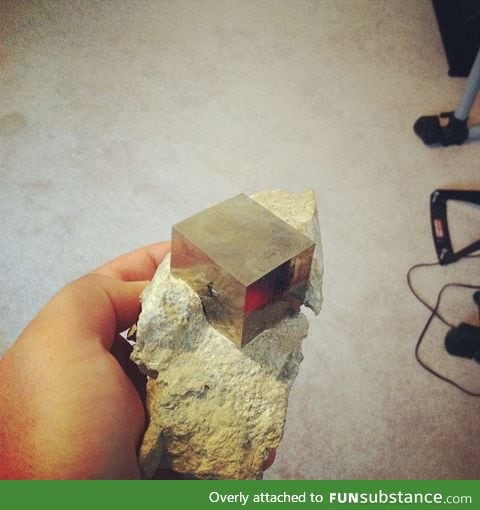 This is a perfect cube of pyrite, in its natural rocky matrix