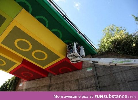 A crew in Germany painting a train bridge overpass to look like Lego blocks