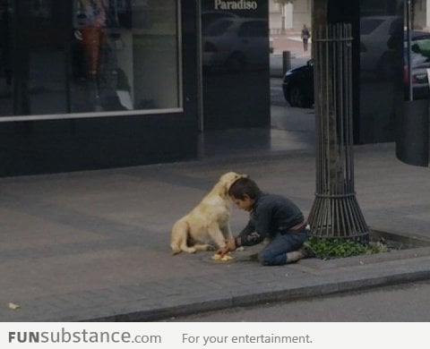 Homeless boy share his food with homeless dog