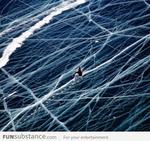 Riding a horse across a frozen lake in the Pamir mountains