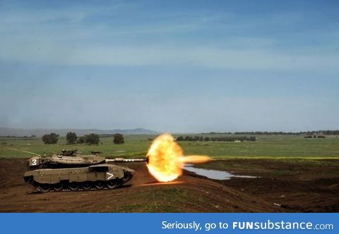 Perfectly timed photo of a tank firing the main gun