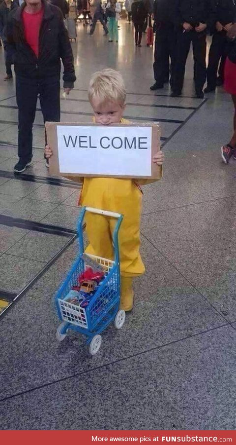 A child waits to welcome refugees at the Munich Central Station giving away what his toys