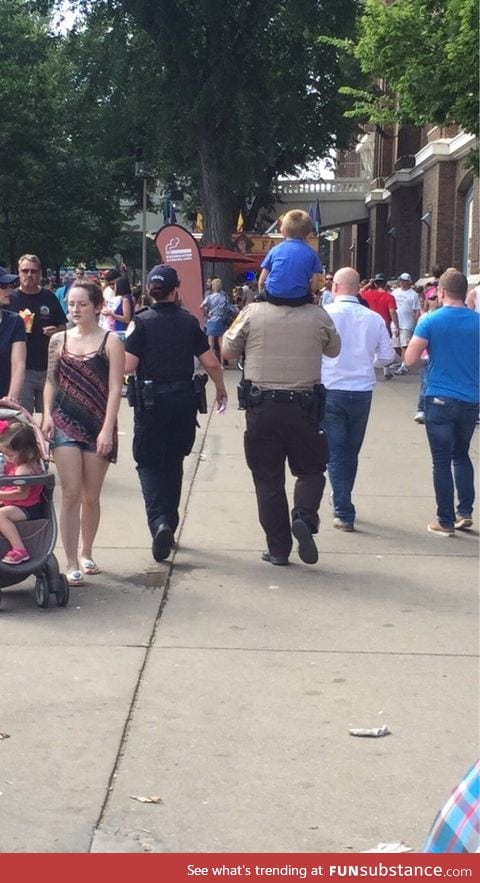This little guy lost his mom at the state fair, and the police man carried him to find her