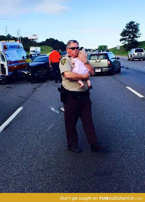 Officer comforts infant after multi-car crash