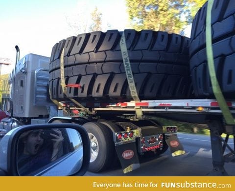 This truck is hauling tires that are wider than the truck