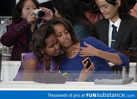 Sasha and Malia take a selfie during the Inaugural Parade