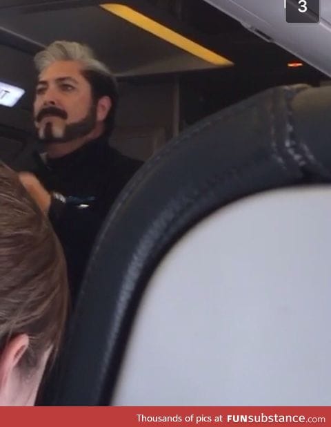 Flight attendant looks like he's about to announce some Hunger Games results