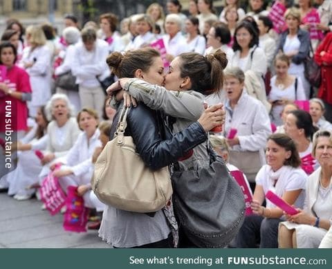 Lesbian couple kisses in front of an anti-gay parade in France