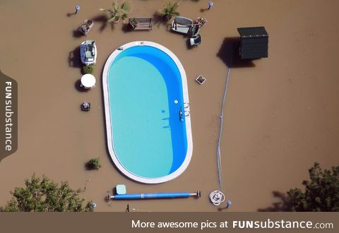 A intact pool between the dirty water of a flood