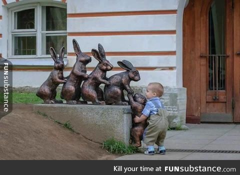 Cute kid trying to help a statue