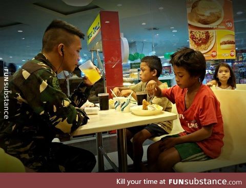 Philippine Air Force man buying meals for two street children