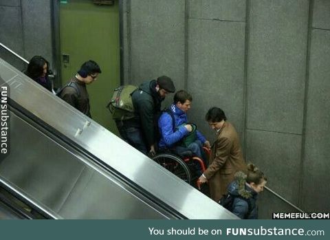 The Canadian Prime Minister helping a man in a wheelchair when the escalator broke down