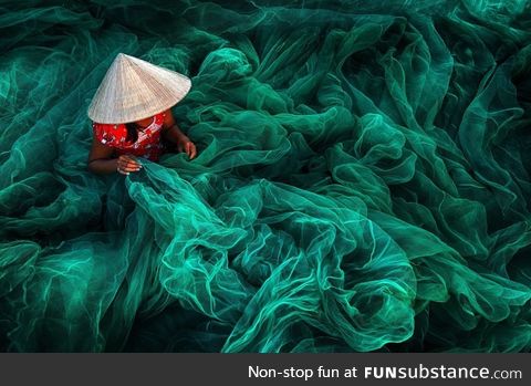 A woman creates a fishing net in a small village near Phan Rang