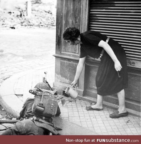 French woman pours tea to a British soldier during the fighting in Normandy, 1944