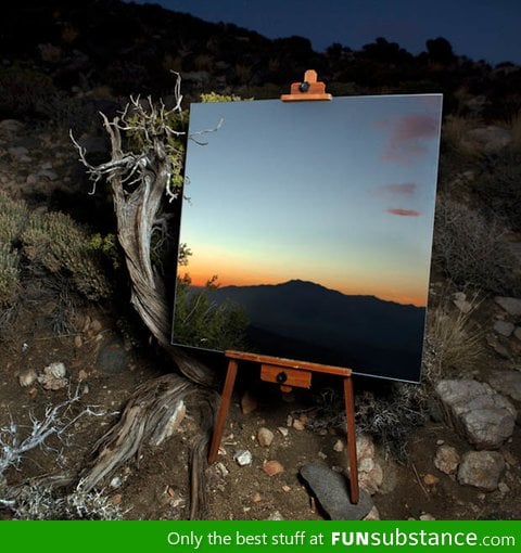 Photograph of a mirror on an easel in the desert that looks like a painting