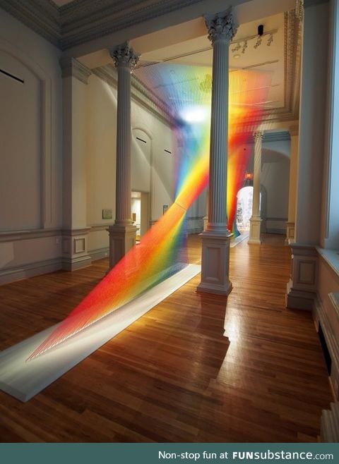 Vibrant rainbow installation made with 60 miles of thread weaves