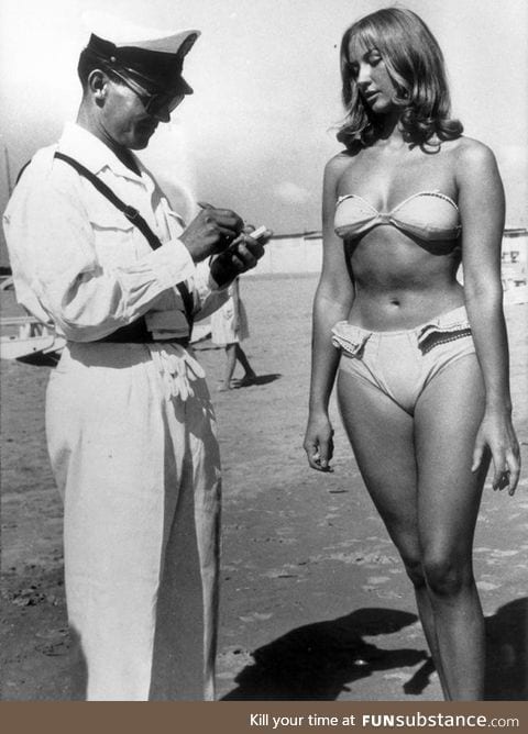 Woman receives ticket for illegally wearing a bikini on a beach. (Italy, circa 1957)