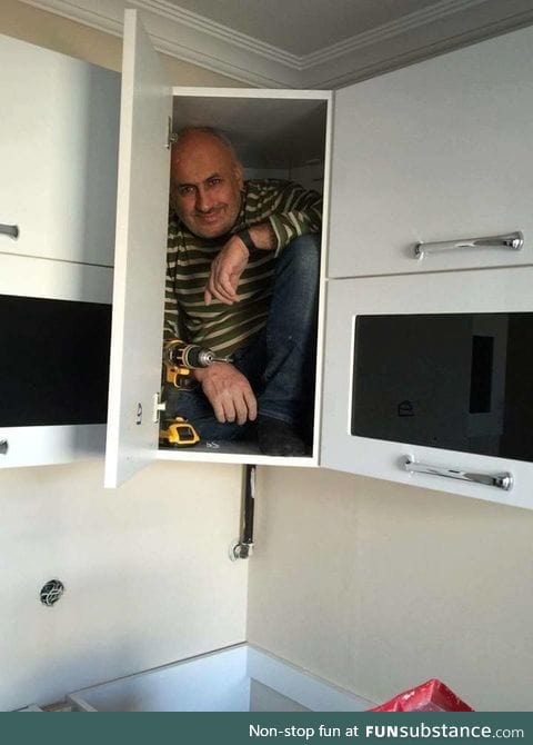 Contractor gets in the cabinet he just build to prove its sturdiness