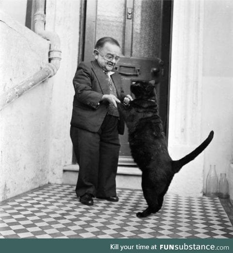 Henry Behrens, the world’s then smallest man, dancing with his cat, 1956