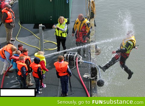 Kids playing with a water hose during coast guard demonstration