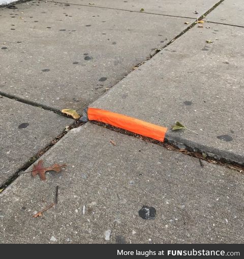 Someone put tape on this raised bit of sidewalk