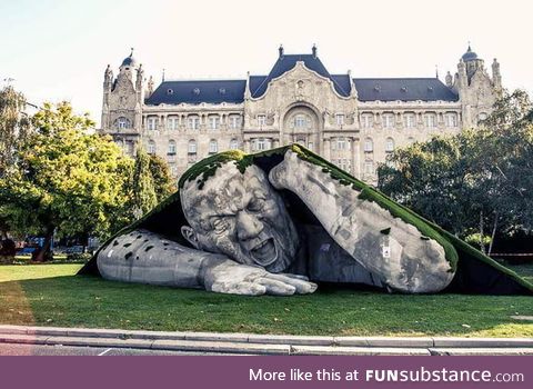 A giant sculpture crawls out of the ground in public square of budapest
