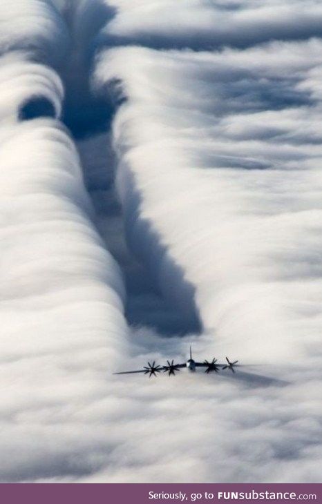 A plane parting clouds with its wingtip vortices