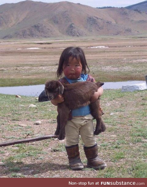 Kid holding a baby goat
