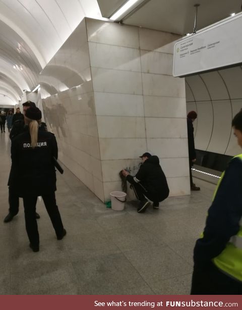 Russian police force Street Artist to clean up the wall