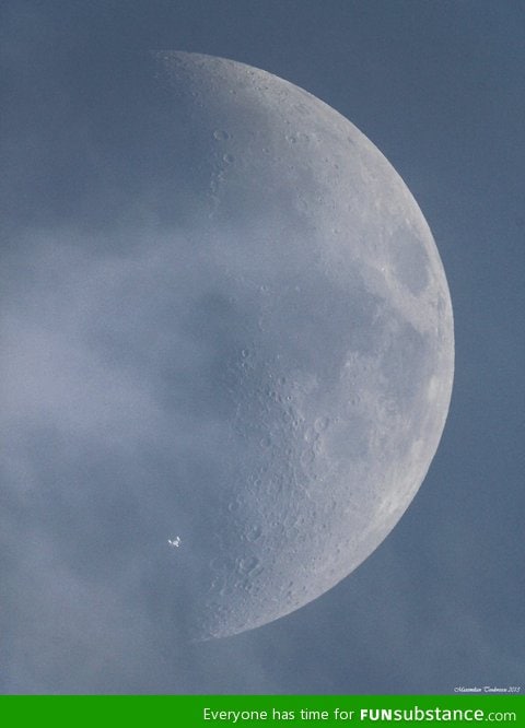 The international space station crosses paths with the moon