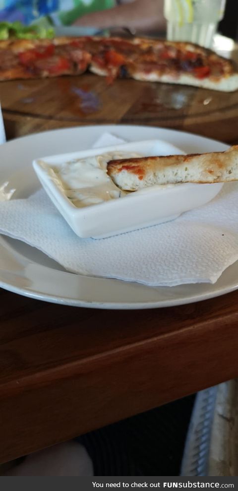 This restaurant serves sauce for the edges of the pizza because a lot of people